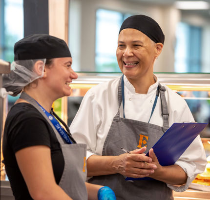 a smiling chef talking to another chef working in industry catering