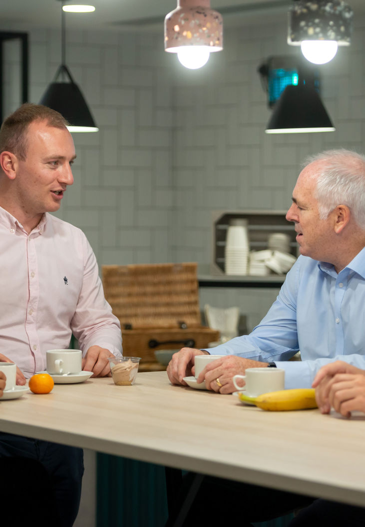 People stood talking around a table discussing business catering and food