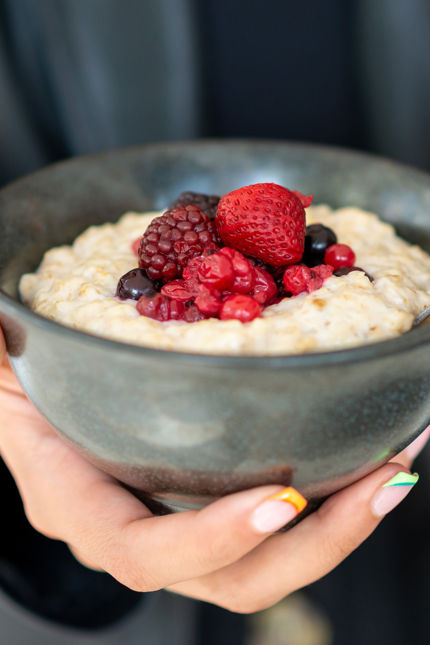 a bowl of porridge topped with fresh berries as part of office catering